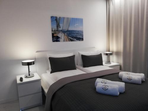 1 dormitorio con 1 cama grande y 2 almohadas en Apartamenty Kapitańskie Bliżej Morza en Kołobrzeg