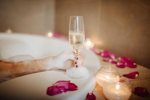 a person holding a wine glass on a table with roses at Hotel Pleamar in Puerto de Vega