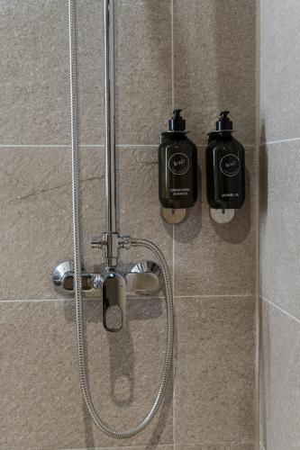 a shower with two bottles on the wall at Nuan Boutique Hotel in Chiang Mai