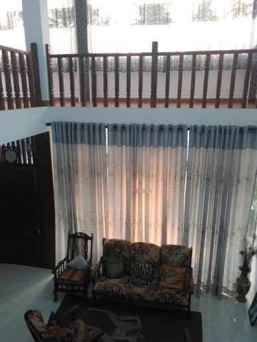 a living room with a couch in front of a window at VILLA ARIANNA in Wattala