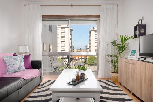 a living room with a couch and a large window at Gaia Center Near Porto in Vila Nova de Gaia