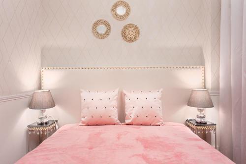 a bedroom with a pink bed with two lamps at Gaia Center Near Porto in Vila Nova de Gaia