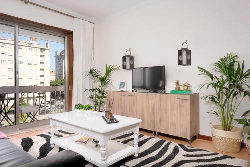a living room with a tv and a white coffee table at Gaia Center Near Porto in Vila Nova de Gaia