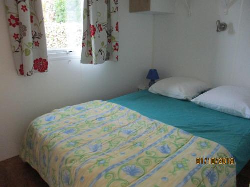 - une chambre avec un lit et une fenêtre dans l'établissement Les Mobile home de KERROYAL, à Garlan