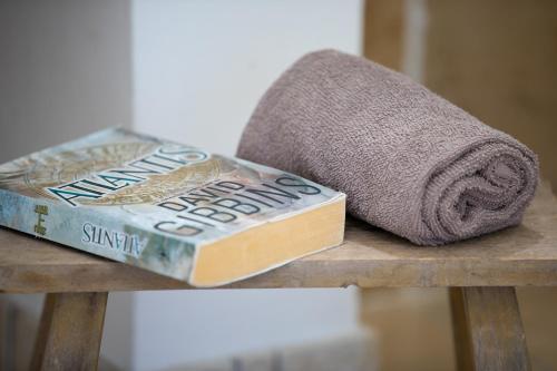 un libro e un asciugamano su un tavolo di legno di Pajara Rugiada a Gagliano del Capo