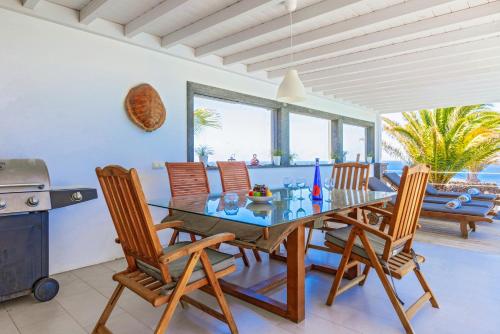 a dining room with a glass table and chairs at Villa Luna Mar - Magnificent Sea Views - Private Pool - Hot Tub in Puerto Calero