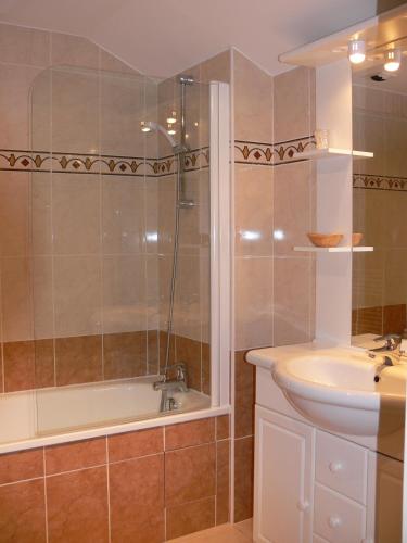 a bathroom with a shower and a tub and a sink at Logis Hotels Le Champalud Restaurant La Citadelle in Champtoceaux