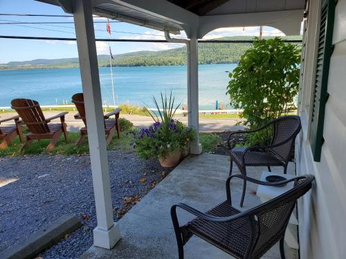 a porch with chairs and a view of the water at Lake View Motel in Cooperstown