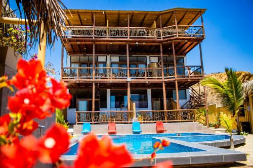 a resort with a swimming pool and a building at Maria Jose Bungalows in Zorritos