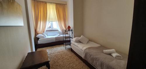 a small room with two beds and a window at APARTAMENT ADA in Kudowa-Zdrój