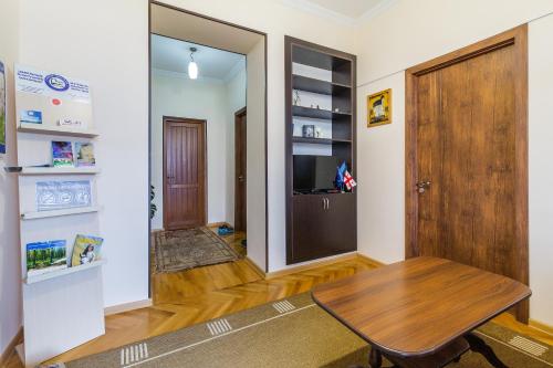 a room with a wooden table and a door at Guest House Gardenia & Wine Cellar in Lagodekhi