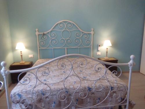 metalowe łóżko z dwoma lampami na dwóch stołach w obiekcie Terre di creta...per sognare w mieście Pomaia