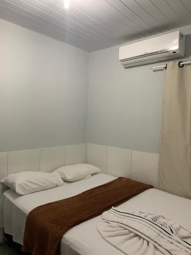 a bedroom with two beds and a air conditioner at Pousada Mar do Sonho Vila in Porto De Galinhas