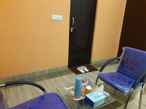a room with a blue chair and a table with a laptop at Yog Bhawan in Greater Noida