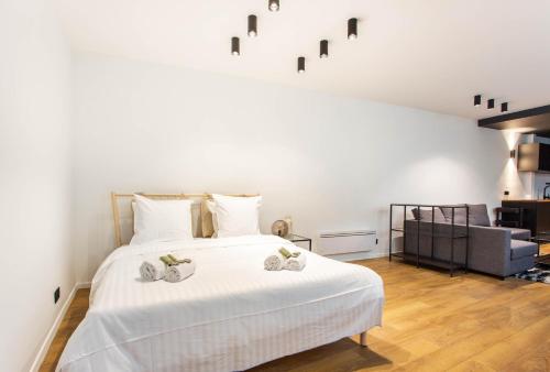 Un dormitorio con una cama blanca con toallas. en Dreamyflat - loft opera, en París