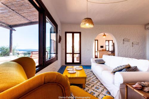- un salon avec un canapé blanc et quelques fenêtres dans l'établissement su mari su entu Isola di Sant'Antioco villa con accesso diretto al mare, à SantʼAntioco Ponti