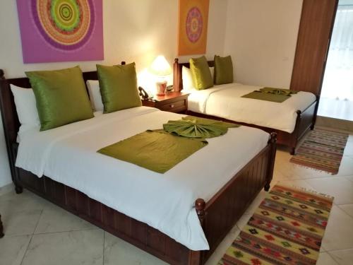 two beds in a hotel room with sidx sidx sidx at Hotel Las Puertas de Tepoztlan in Tepoztlán