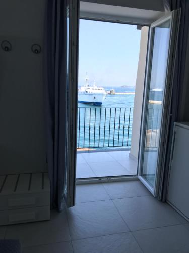 a door leading to a balcony with a cruise ship in the water at Vento di mare in Procida