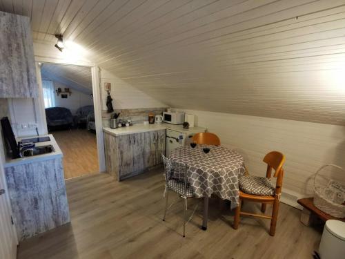 cocina y comedor con mesa y sillas en GARDEN CHALET, en Daugavpils