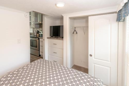 a bedroom with a bed and a kitchen at Sun Outdoors Petoskey Bay Harbor in Petoskey