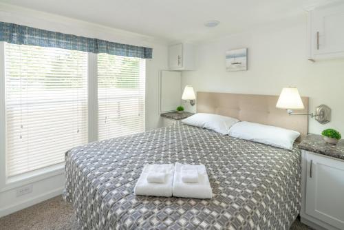 a bedroom with a bed with two towels on it at Sun Outdoors Petoskey Bay Harbor in Petoskey