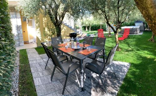 a black table and chairs in a yard at Villa Lori Apartments Garden and Beach in Peschiera del Garda