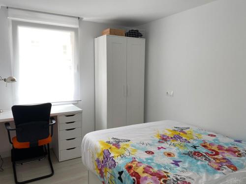 una camera con letto, scrivania e sedia di Marisol apartament a Santiago de Compostela