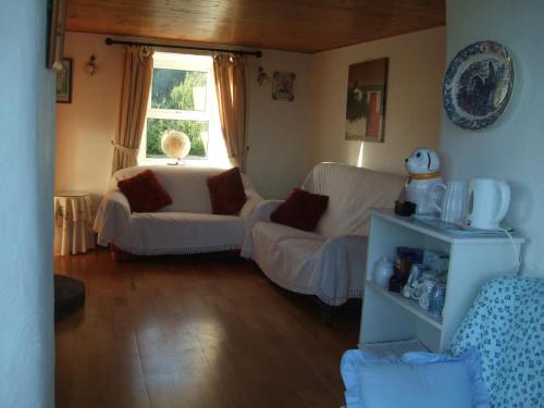 a living room with a couch and a window at Reenmore Farmhouse in Ahakista