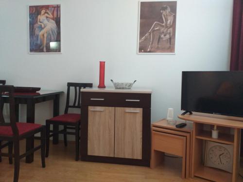 un soggiorno con TV e tavolo con sedie di Apartman Nadja i Djole a Soko Banja