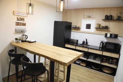 a kitchen with a wooden table and black appliances at Aires do Umia in Caldas de Reis