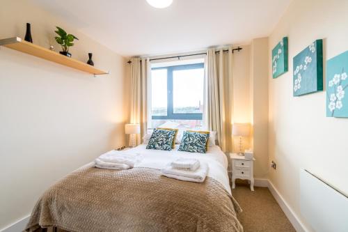 a bedroom with a bed with towels on it at Spacious City 2 Bed, 2 Bath, FREE PARKING & WiFi in Sheffield