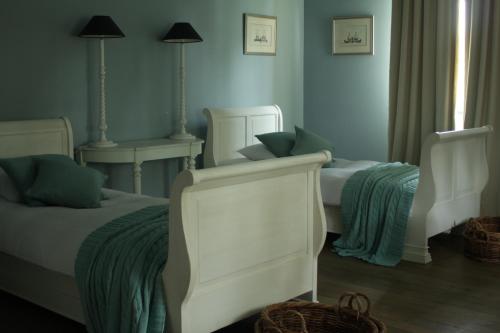 a bedroom with two twin beds and two lamps at Rose Residence in Dobroszyce