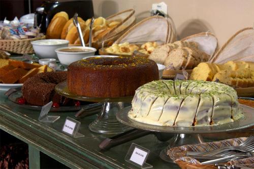 a table with a cake and other baked goods on it at Pousada Porto Mare in Maresias