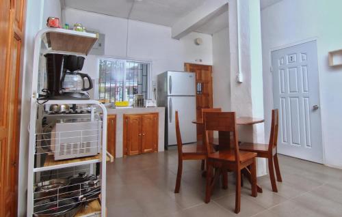 a kitchen with a table and a refrigerator at Rainforest Haven Inn in San Ignacio
