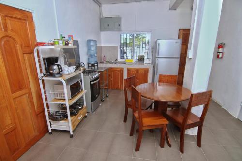 a small kitchen with a table and a refrigerator at Rainforest Haven Inn in San Ignacio