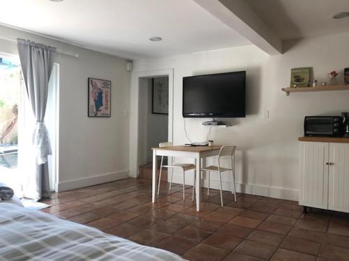 a bedroom with a table and a tv on the wall at Little havana paradise in Miami