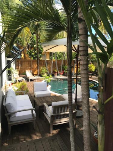a patio with chairs and a swimming pool with palm trees at Little havana paradise in Miami