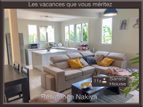 a living room with a couch and a kitchen at Résidence Nakiya in Sainte-Marie