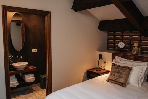 a bedroom with a bed with a sink and a mirror at 1930 Boutique Hotel in Arzúa