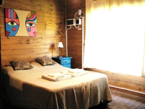 1 dormitorio con 1 cama con toallas en Cabañas Bocas del Tigre en Tigre
