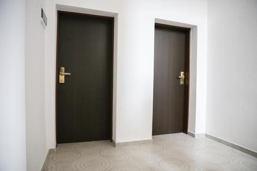 two black doors in a hallway with white walls at OASIS Teplice in Teplice