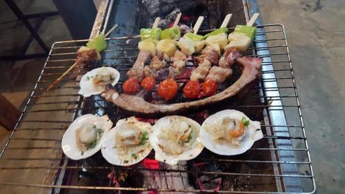 a grill with meat and other food on it at ชลลดา ริเวอร์ โฮมสเตย์ แก่งกระจาน in Ban Wang Malako