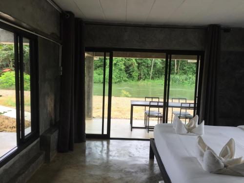 a bedroom with two beds and a view of a patio at ชลลดา ริเวอร์ โฮมสเตย์ แก่งกระจาน in Ban Wang Malako