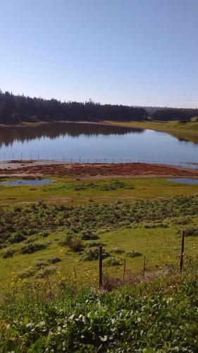 a field with a lake and a fence in front of it at Casa Familiar Santo Domingo in El Convento