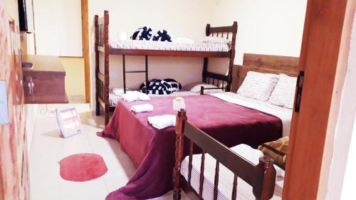 a bedroom with two bunk beds with red sheets at Suites Bella vista in Campos do Jordão