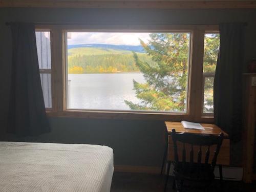 a bedroom with a view of a lake from a window at Jasper Way Inn Resort & Campground in Clearwater