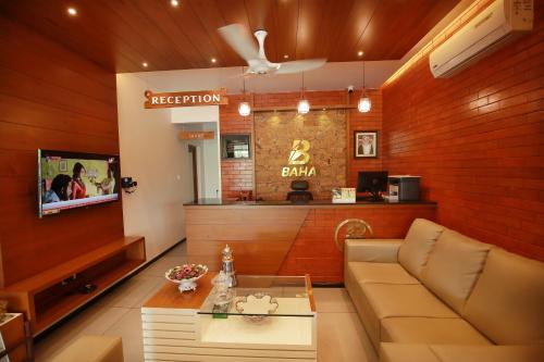 a living room with a couch and a bar at HOTEL BAHA in Ernakulam