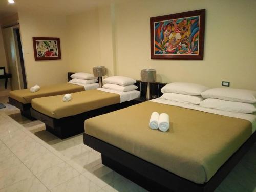 a room with three beds in a room at Royale House Hotel Davao powered by Cocotel in Tagum