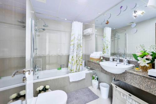 a bathroom with a sink and a tub and a toilet at Beautiful 2Bed 2Baclcony in JLT, Dubai in Dubai