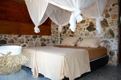 a bedroom with a bed with curtains on it at Ecoresort Sumba Dream in Rindi